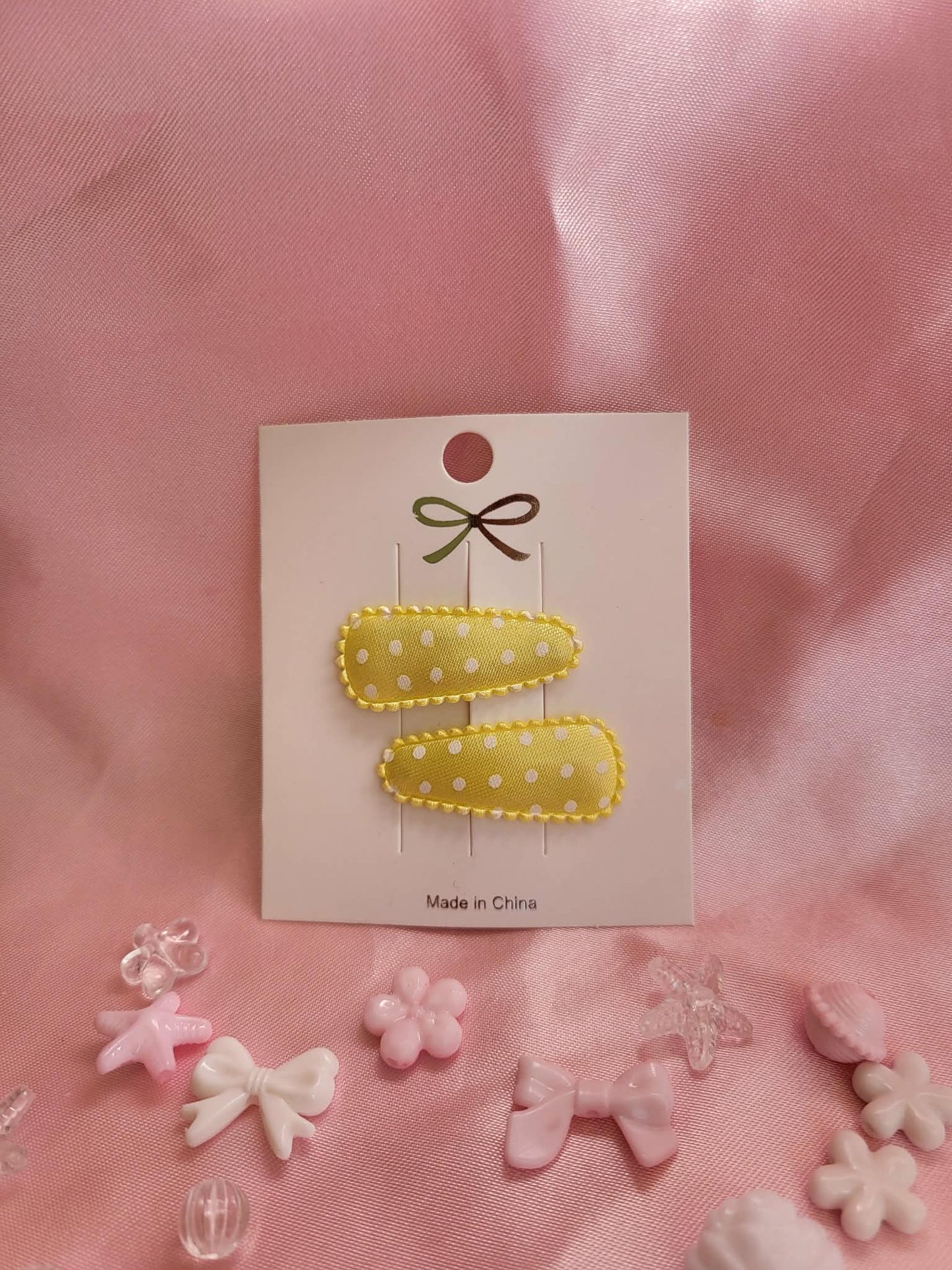 Baby klikspeld satijn geel met witte stippen