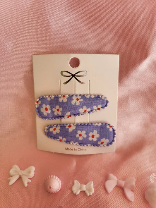 Kind klikspeld paars met witte bloemen en gekleurde stippen