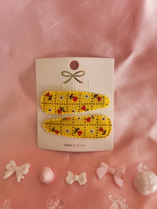 Kind klikspeld geel met kleine bloemetjes