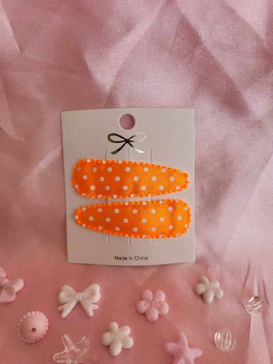 Kind klikspeld satijn oranje met witte stippen